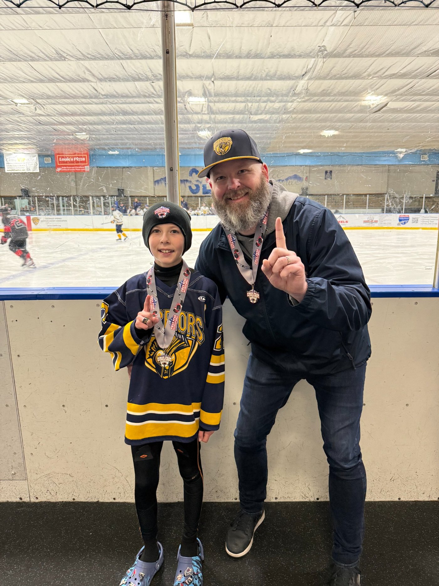 A hockey parent and young player together at the rink after a tournament